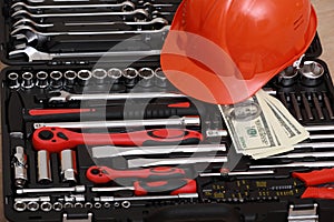 Toolbox, tools kit detail, dollar bills and orange protective helmet close up. instruments. set of tools. car tool kit. tool set