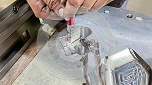 a toolmaker adjusting a plastic injection mold with a grinder, mechanical adjustment of a mold, die setter adjusting hands