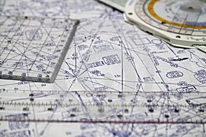 Tools for airplane pilots consisting of navigation computer, protractor, scale ruler against airway navigation chart in the