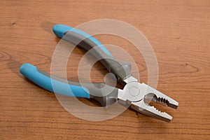 Tools, blue pliers on a walnut table