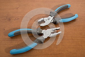 Tools, blue pliers on a walnut table
