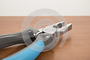 Tools, blue pliers on a walnut table