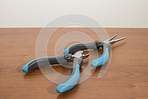 Tools, blue pliers on a walnut table