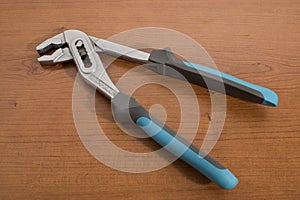 Tools, blue pliers on a walnut table