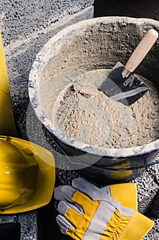 Tools for bricklayer bucket with a solution and a trowel, close