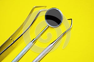 Tools for dental treatment on a yellow background