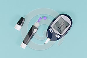 Tools for diabetes treatment with blood glucose sugar meter showing blood sugar of 94 and lancing device with lancet