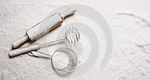 Tools for dough - a rolling pin, the whisk and sieve in the flour.