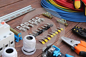 Tools for electrical work laid out on a wooden surface of brown