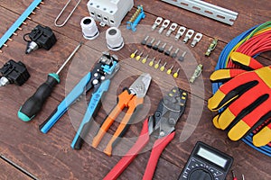 Tools for electrical work laid out on a wooden surface of brown