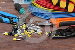 Tools for electrical work laid out on a wooden surface of brown