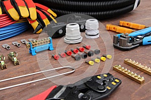 Tools for electrical work laid out on a wooden surface of brown