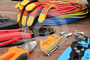 Tools for electrical work laid out on a wooden surface of brown