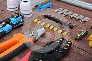 Tools for electrical work laid out on a wooden surface of brown