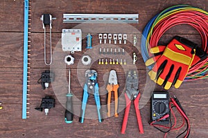 Tools for electrical work laid out on a wooden surface of brown. Top view