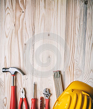 Tools, hardhat on wooden desk, top view