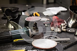 Tools and hardware on workshop table. Workplace of a metal machinist producing medieval armour suits