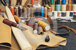 Tools and leather at cobbler workplace. Set of leather craft tools on wooden background