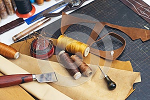 Tools and leather at cobbler workplace. Set of leather craft tools on wooden background