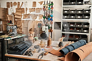 Tools and material sitting on a leather studio workbench