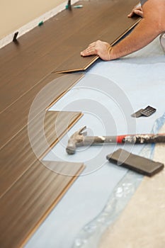 Tools next to Man Installing New Laminate Wood Flooring