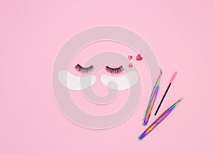 Tools and patches for eyelash extensions and artificial eyelashes on a pink background. Tools for the lashmaker. The view from the