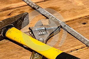 Tools for repair and building. Hummer, adjustable spanner, ruler. Instruments on rustic wooden table with copy space