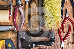 Tools for repair: roller, chisel, pliers, glass cutter on a wooden background close-up