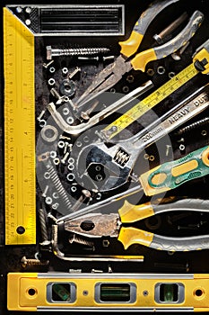 Tools, screws and nuts on a metallic background