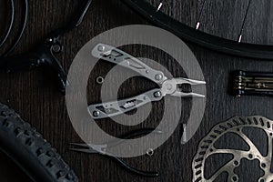 Tools on the table. flat lay. brake disc, multitool, pliers, flashlight, brake tool for a bicycle