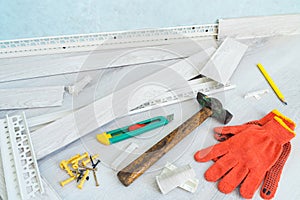 Tools to instal plastic skirting board on laminate flooring. Renovation of baseboard at home.