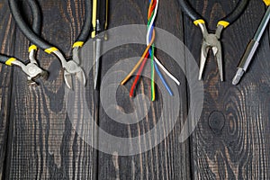Werkzeuge a das Kabel Elektriker bereit Vor fix auf der Schwarz hölzern Bretter 