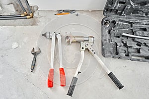 Tools for Work As A Plumber. Connection heating pipes to white Radiator in a new apartment under construction. water