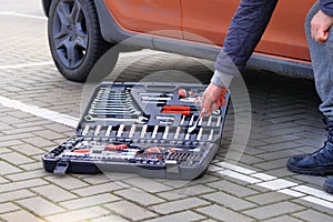 Toolset near the auto. Mechanical workshop tools. Ð¡ar mechanic using different repair tools for repairing an car