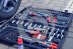 Toolset near the auto. Mechanical workshop tools in box. Using different repair tools for repairing an car