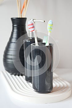 Tooth brushes in glass on table