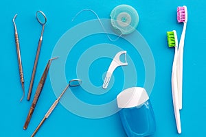 Tooth care with toothbrush, dental floss and dentist instruments. Set of cleaning products for teeth on blue background