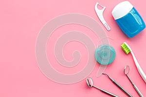 Tooth care with toothbrush, dental floss and dentist instruments. Set of cleaning products for teeth on pink background