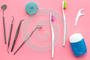 Tooth care with toothbrush, dental floss and dentist instruments. Set of cleaning products for teeth on pink background