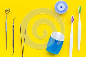 Tooth care with toothbrush, dental floss and dentist instruments. Set of cleaning products for teeth on yellow