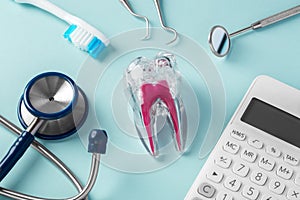 Tooth with dentist tools and calculator on blue background, dental cost
