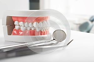Tooth model and dental tools on the table in dentist office