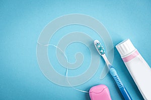 Tooth paste, brush and dental floss on blue background. cleaning and protection of teeth.