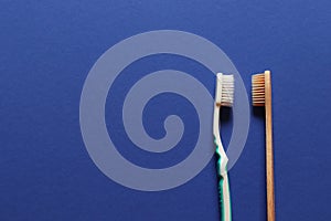 Tooth plastic brush and wooden brush on a blue background
