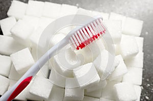 Toothbrush on the background of the sugar cubes of refined sugar, preventing tooth decay, caring for the health of your teeth