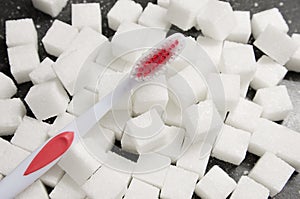 toothbrush on the background of the sugar cubes of refined sugar, preventing tooth decay, caring for the health of your teeth
