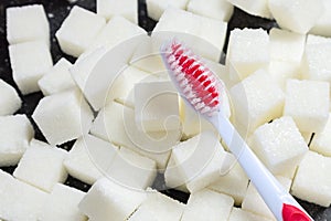 Toothbrush on the background of the sugar cubes of refined sugar, preventing tooth decay, caring for the health of your teeth