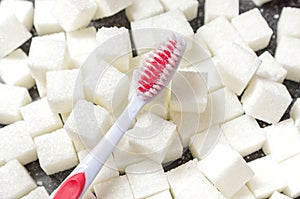 Toothbrush on the background of the sugar cubes of refined sugar, preventing tooth decay, caring for the health of your teeth