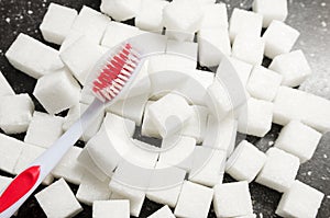 toothbrush on the background of the sugar cubes of refined sugar, preventing tooth decay, caring for the health of your teeth