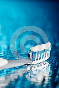 Toothbrush on blue background with water drops